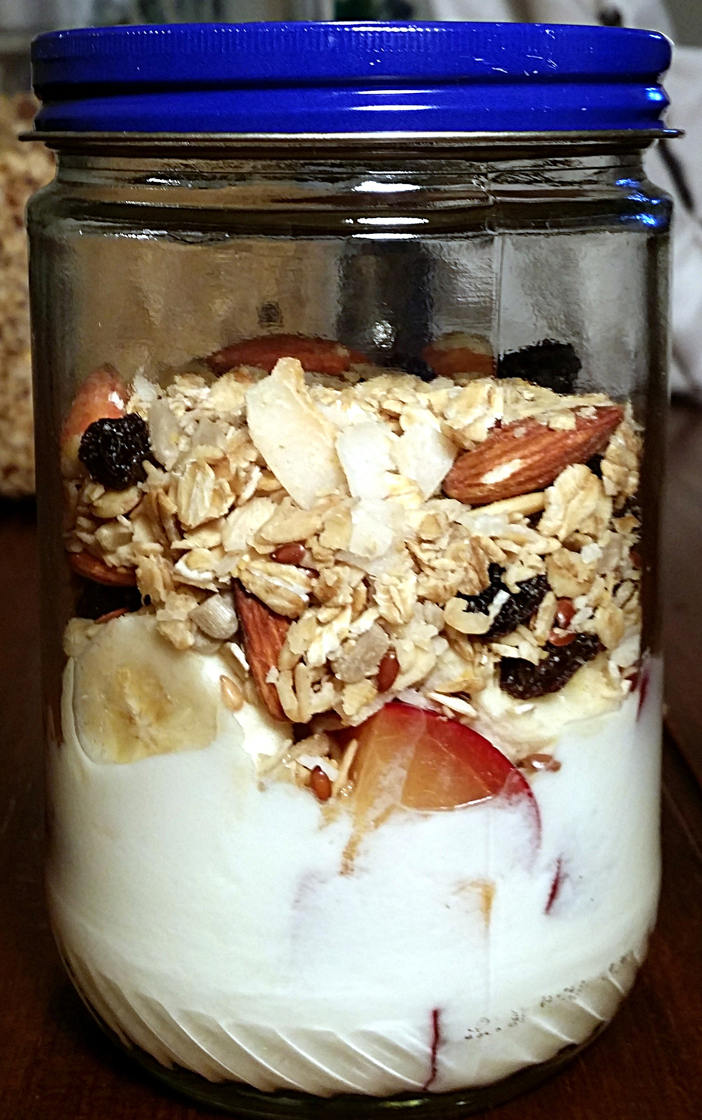 a glass jar is filled with yogurt on the bottom and topped with homemade granola