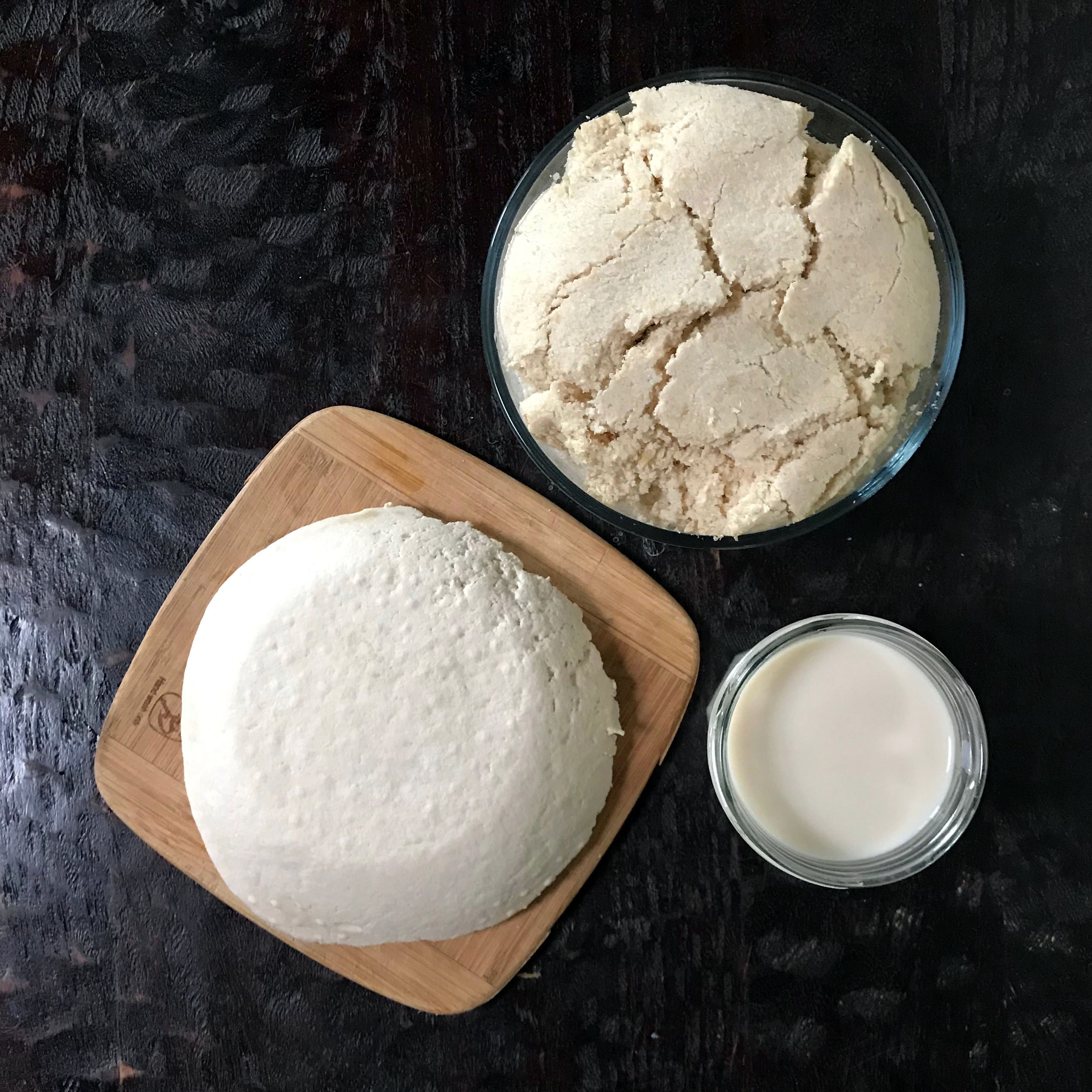 a small jar of homemade soy milk, a slab of tofu and a bowl of okara