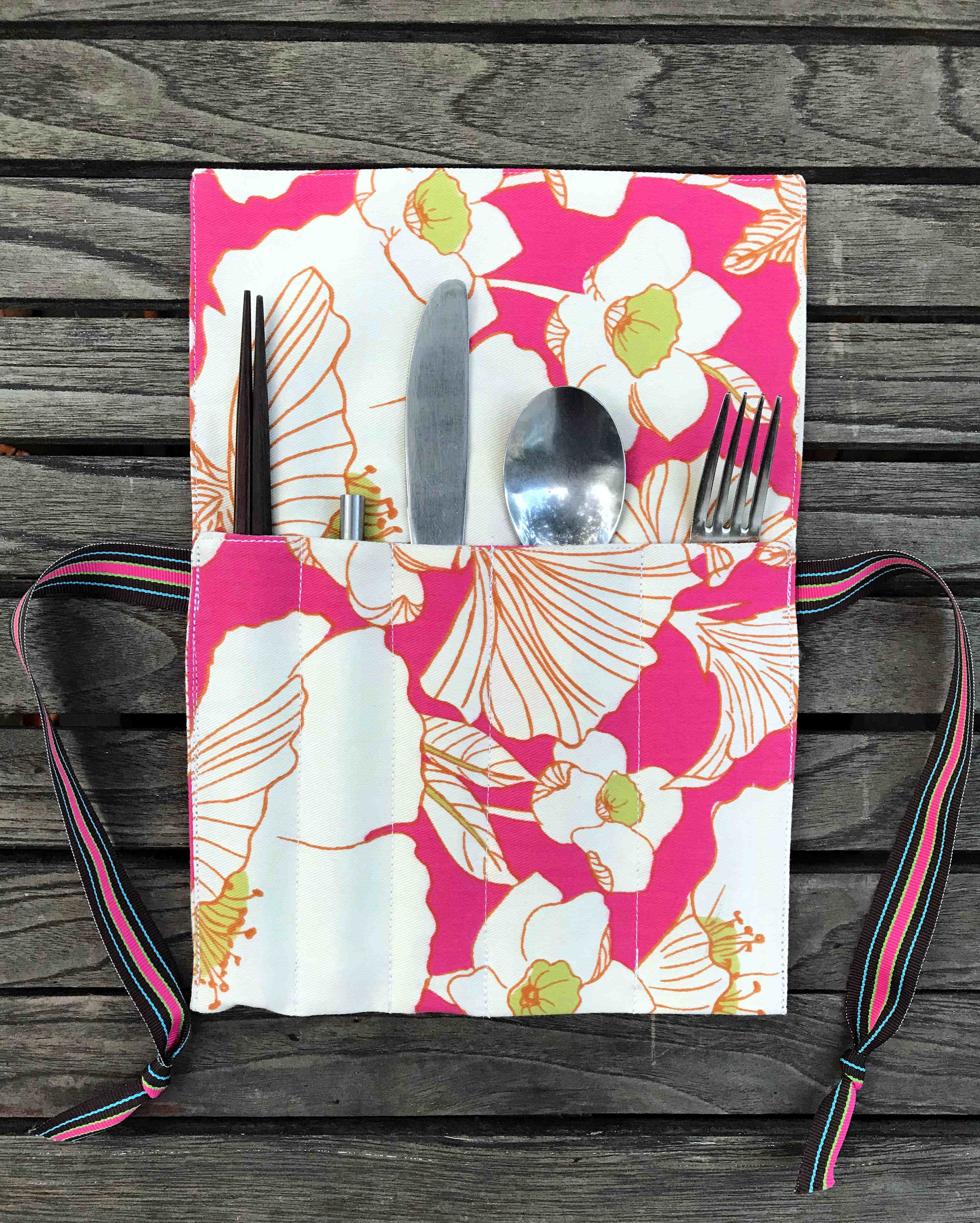 a floral patterned utensil roll for carrying cutlery and avoiding single-use plastic