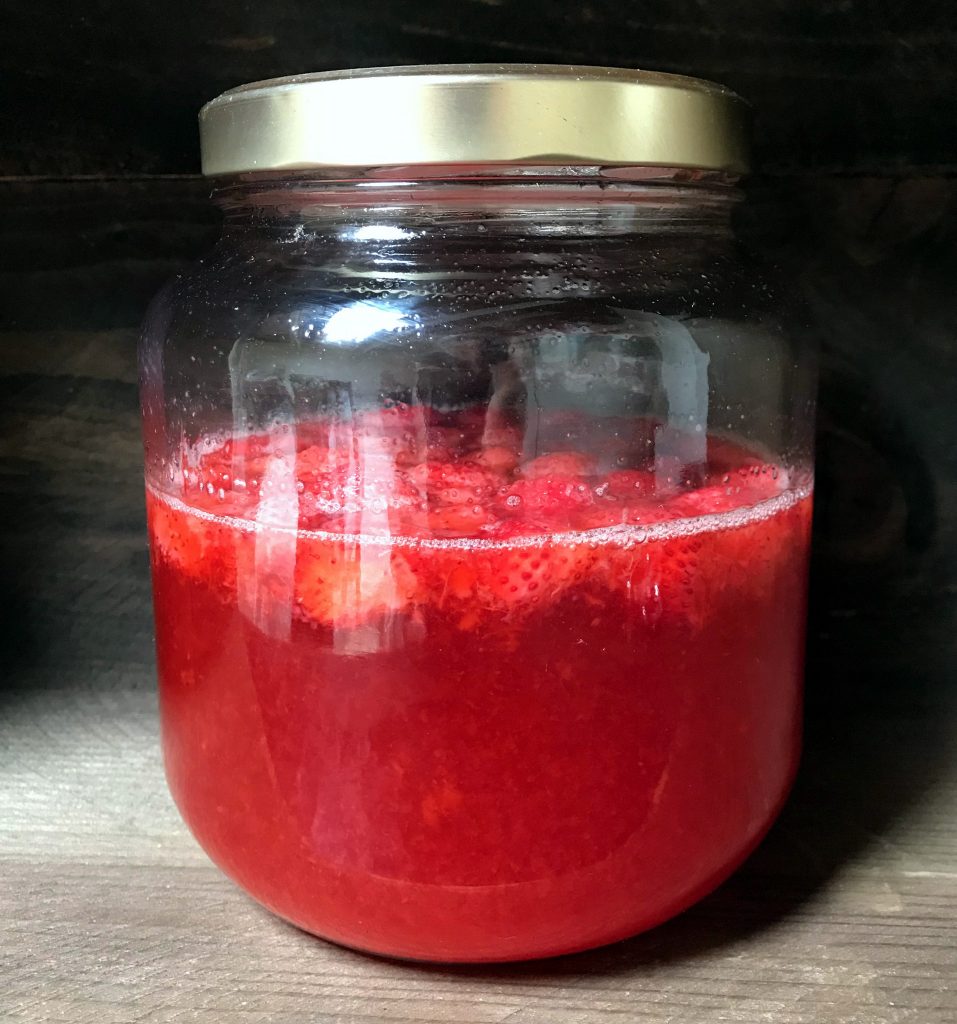 naturally fermented strawberry soda brewing in a jar