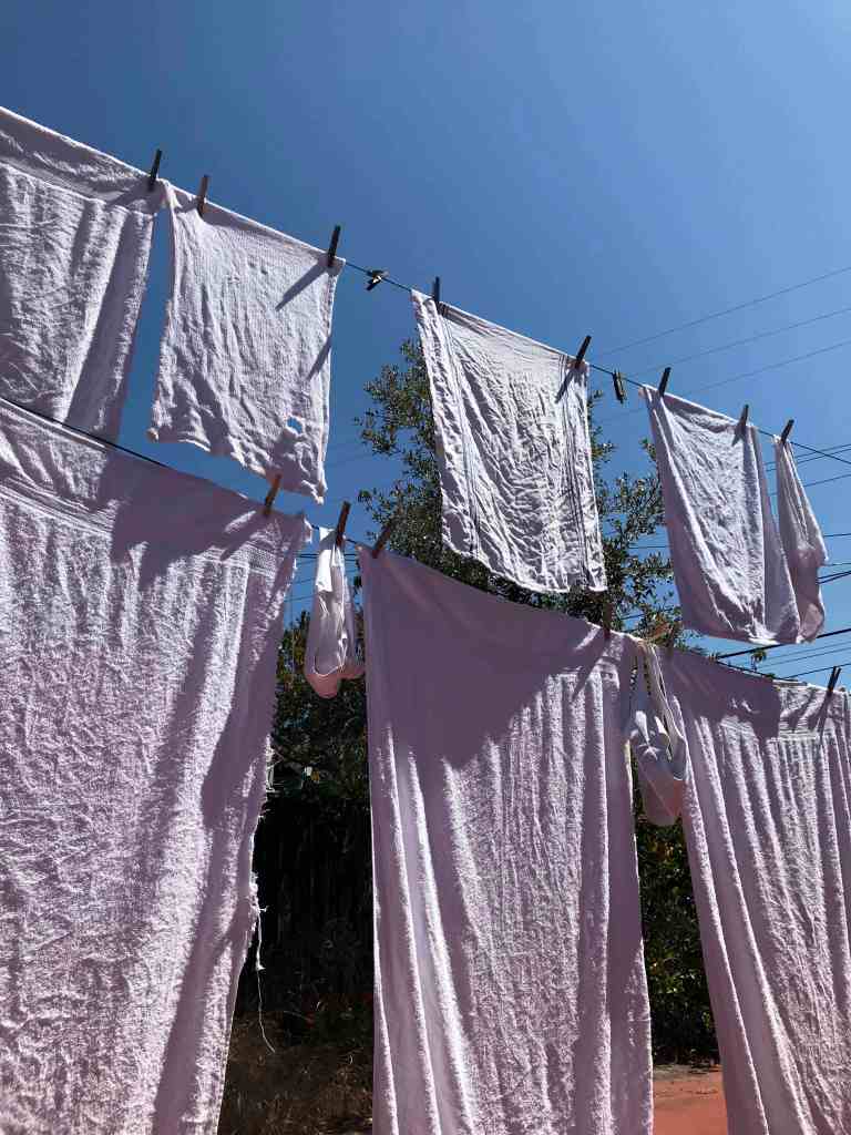 white towels drying outside passively in the sun