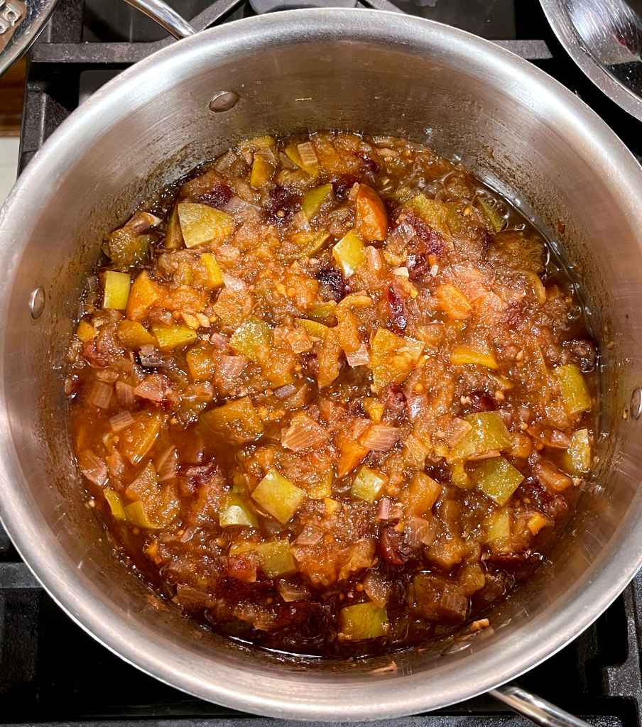cooked apple-cranberry chutney in a stainless steel pot on the stove