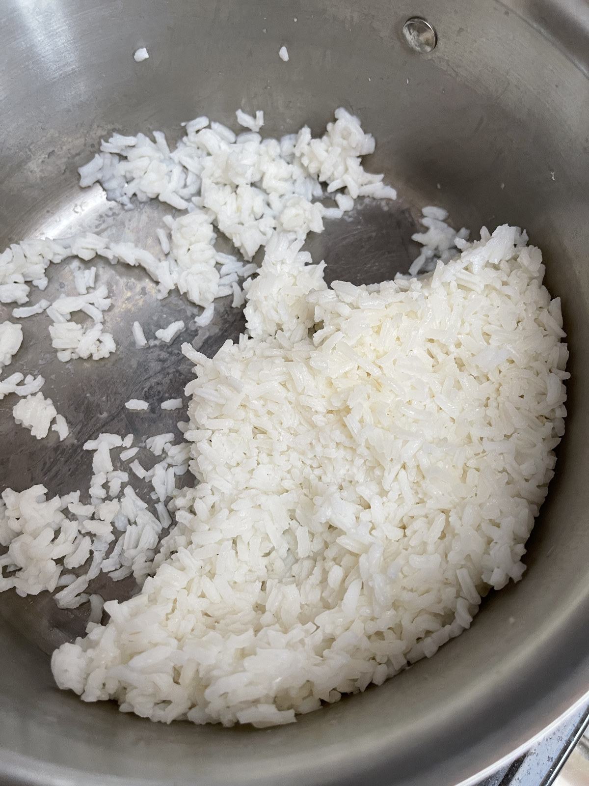 Leftover cooked white rice in a stainless steel pot