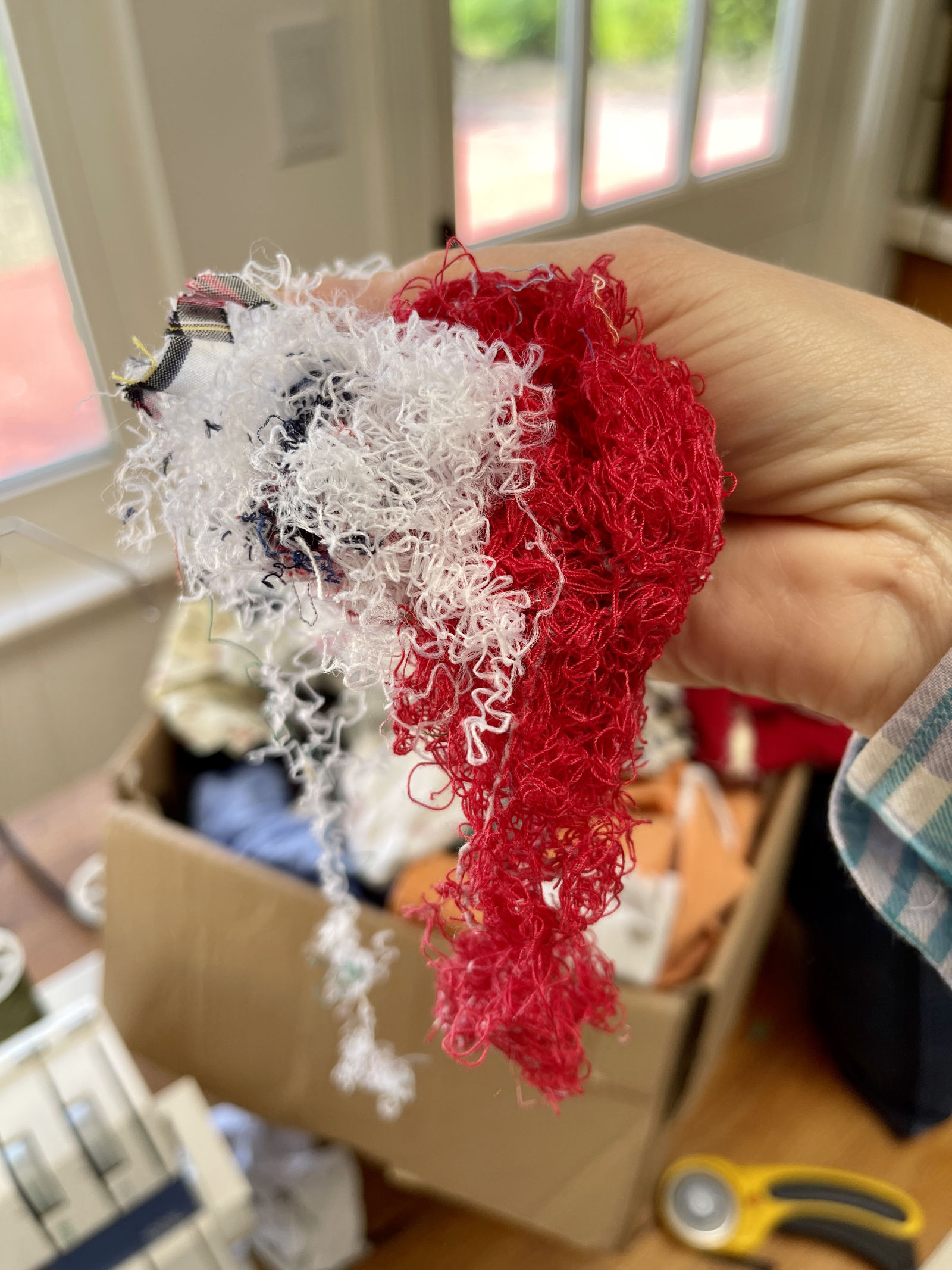 A handful of red and white threads for stuffing a denim garden kneeling pad