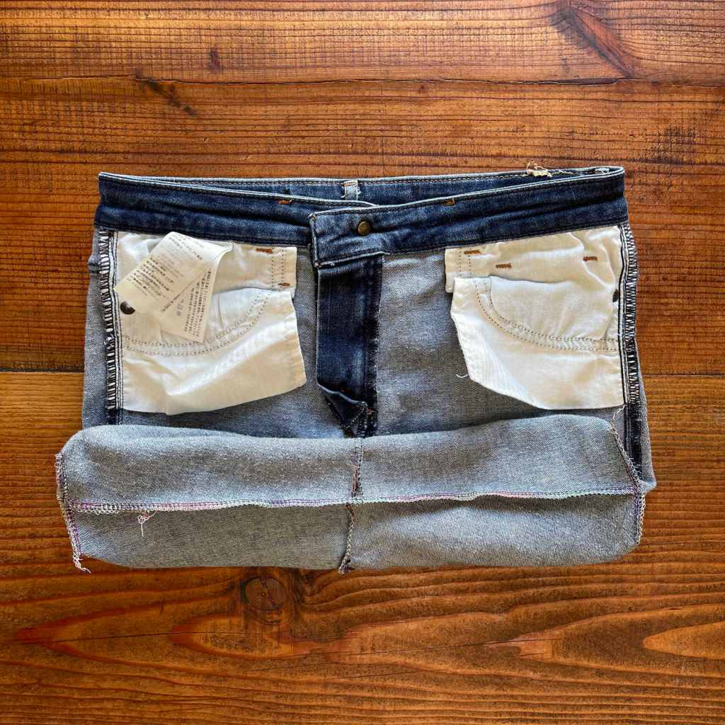 View of a flat bottom inside a denim shopping bag made with old jeans. The handles have not been sewn on yet.