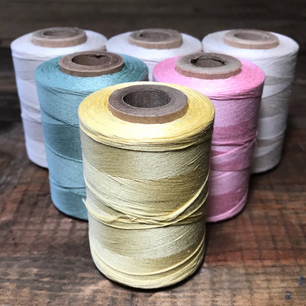 Thick spools of thread in bright colors wound on cardboard spools